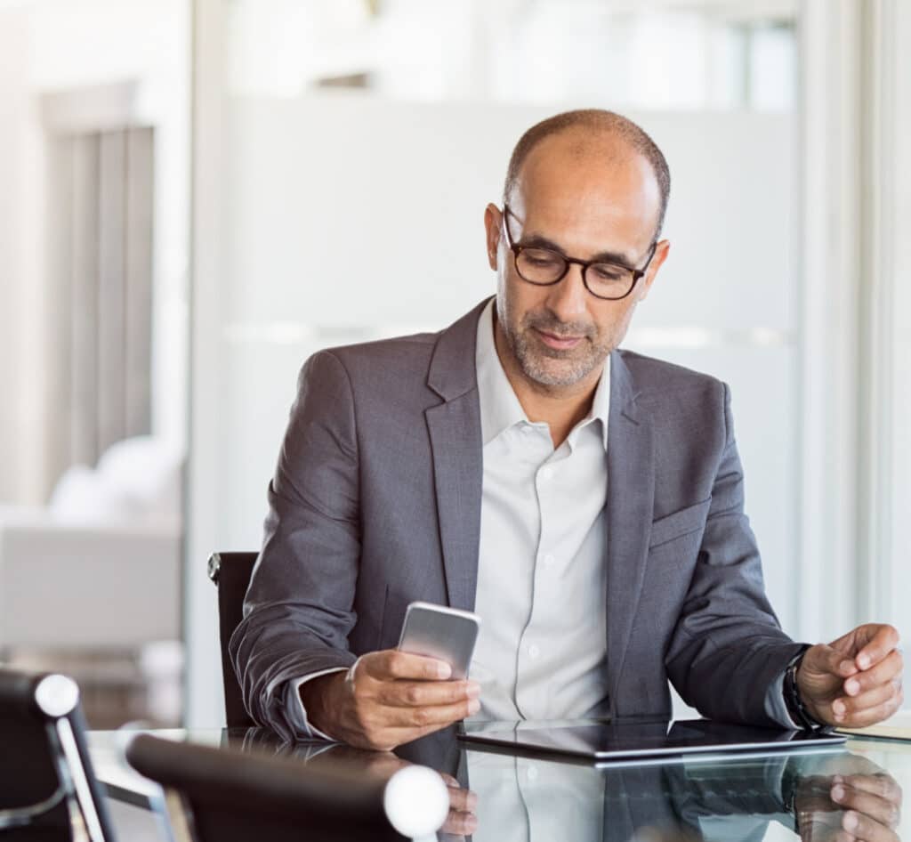 Businessman in gray suit looking at smartphone