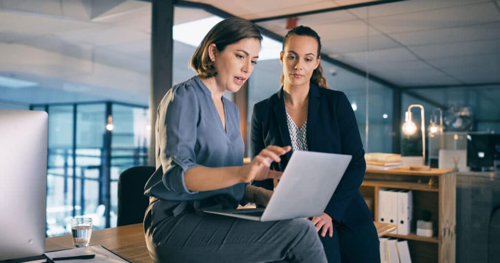 two businesswomen looking at laptop in office